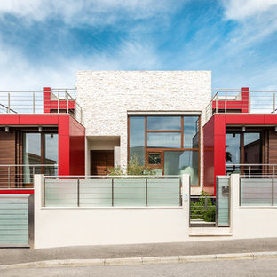 Esempio della facciata di una casa unifamiliare rossa contemporanea con rivestimenti misti e tetto piano