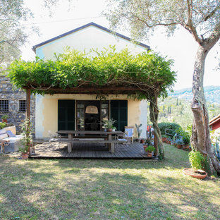 Foto della facciata di una casa unifamiliare bianca mediterranea a due piani con rivestimento in stucco, tetto a capanna e copertura in metallo o lamiera