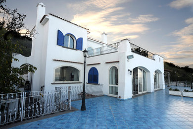 Diseño de fachada blanca mediterránea grande de dos plantas