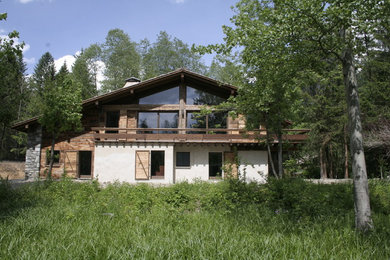 Diseño de fachada de casa rústica grande de dos plantas con tejado a dos aguas y tejado de teja de madera