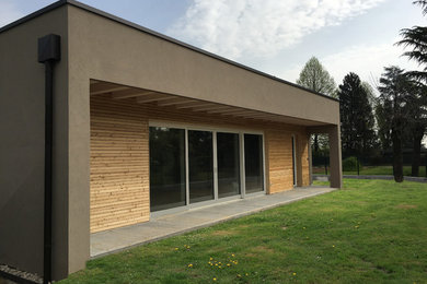 Ejemplo de fachada de casa beige actual de tamaño medio de una planta con revestimientos combinados y tejado plano