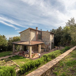 Ispirazione per la facciata di una casa unifamiliare beige country a due piani con rivestimento in pietra, tetto a una falda e copertura in tegole