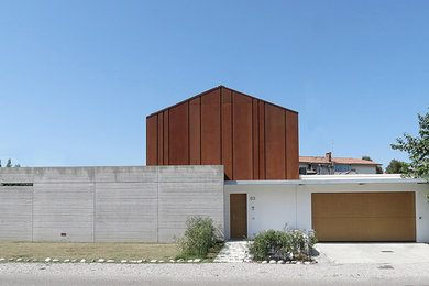 Foto della villa grande grigia contemporanea a due piani con rivestimento in metallo, tetto a capanna e copertura in metallo o lamiera