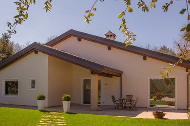 Foto de fachada de casa blanca mediterránea de tamaño medio de dos plantas con revestimientos combinados, tejado a dos aguas y tejado de teja de barro