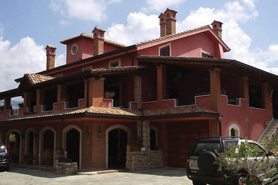 Foto della facciata di una casa ampia rossa country a due piani con tetto a mansarda