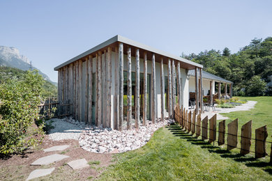 Diseño de fachada blanca rural de tamaño medio de una planta con revestimiento de madera, tejado plano y tejado de metal