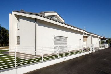 Esempio della facciata di una casa bifamiliare bianca moderna a un piano di medie dimensioni con rivestimento in stucco, tetto a capanna, copertura in tegole e tetto grigio