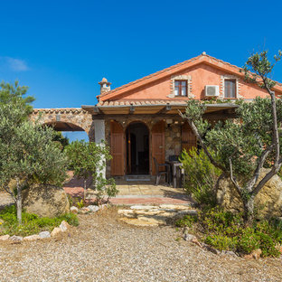 Esempio della facciata di una casa rossa mediterranea a due piani di medie dimensioni con rivestimenti misti e tetto a capanna