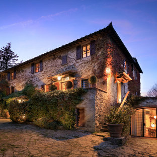 Foto della facciata di una casa unifamiliare beige mediterranea a tre piani con rivestimento in pietra