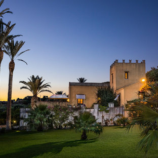 Idee per la facciata di una casa unifamiliare gialla mediterranea a due piani con tetto a capanna e copertura in tegole