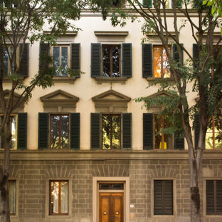 Cette image montre un très grand façade d'immeuble traditionnel avec un revêtement mixte, un toit à deux pans et un toit en tuile.