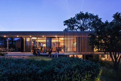 Idee per la facciata di una casa ampia contemporanea a un piano con rivestimento in legno e tetto piano