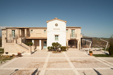 Diseño de fachada de casa naranja mediterránea de dos plantas con revestimiento de ladrillo, tejado a dos aguas, tejado de teja de barro y escaleras