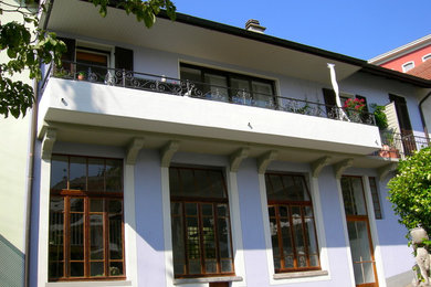 Idee per la facciata di una casa classica a tre piani con tetto a mansarda