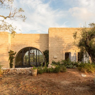 Ispirazione per la facciata di una casa beige mediterranea con rivestimento in pietra