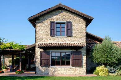 Cette image montre une façade de maison rustique en brique de taille moyenne et à un étage avec un toit à deux pans.
