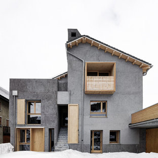 Foto della villa grigia contemporanea a tre piani con tetto a capanna