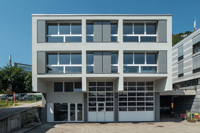 Foto de fachada gris actual grande de tres plantas con tejado plano