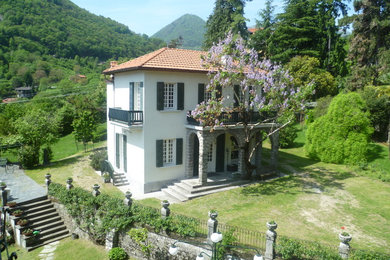 Cette photo montre une grande façade de petite villa blanche chic à un étage avec un toit à quatre pans.