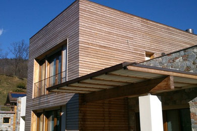 Foto della facciata di una casa bianca contemporanea con rivestimento in legno e tetto piano