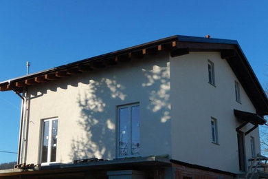 Immagine della facciata di una casa bianca contemporanea a due piani di medie dimensioni con rivestimento in stucco e copertura in tegole