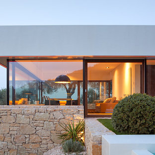 Idee per la facciata di una casa bianca stile marinaro di medie dimensioni con rivestimento in pietra e tetto piano