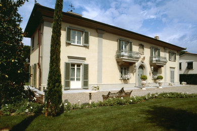 Foto della facciata di una casa ampia beige classica a due piani con rivestimento in cemento