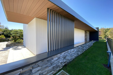 Idee per la villa bianca contemporanea a un piano di medie dimensioni con rivestimento in pietra, tetto piano e copertura verde