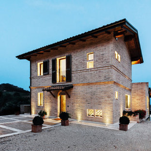 Esempio della facciata di una casa unifamiliare rossa country a due piani con rivestimento in mattoni, copertura in tegole e tetto a capanna