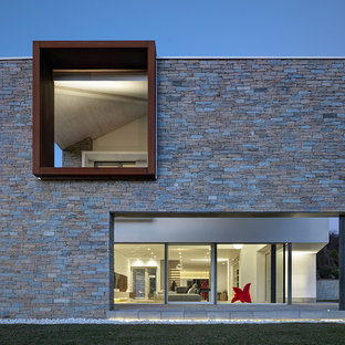 Ispirazione per la villa grande grigia moderna a due piani con rivestimento in pietra e tetto piano