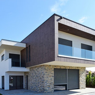 Ispirazione per la facciata di una casa moderna a due piani con rivestimento in pietra e tetto piano