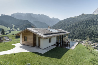 Diseño de fachada de casa blanca rural de tamaño medio de una planta con tejado a dos aguas y revestimiento de madera