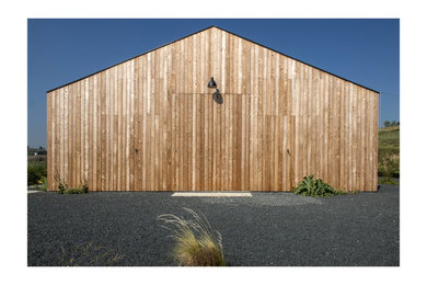 Foto della facciata di una casa country a un piano con rivestimento in legno e tetto a capanna