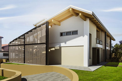 Immagine della facciata di una casa a schiera gialla contemporanea a due piani di medie dimensioni con copertura in metallo o lamiera