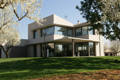 Imagen de fachada blanca actual de tamaño medio de dos plantas con revestimientos combinados y tejado de un solo tendido