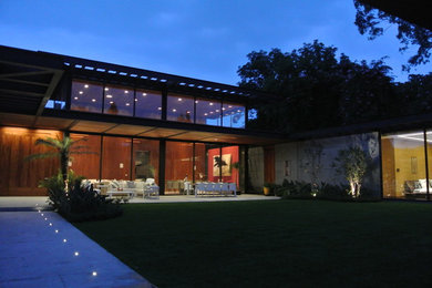 Modelo de fachada contemporánea de una planta con revestimiento de vidrio y tejado plano