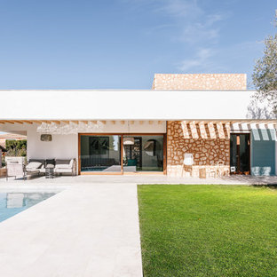 Idee per la villa bianca mediterranea a un piano con tetto piano e rivestimento in pietra