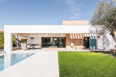 Свежая идея для дизайна: одноэтажный, белый частный загородный дом в средиземноморском стиле с плоской крышей и облицовкой из камня - отличное фото интерьера