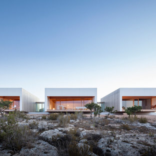Ejemplo de fachada de casa gris, moderna, de tamaño medio, de dos plantas, con revestimiento de madera, tejado plano y tejado de varios materiales