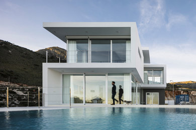 Modelo de fachada de casa blanca moderna grande de dos plantas con revestimiento de aglomerado de cemento, tejado plano y tejado de varios materiales