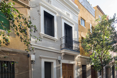 Ejemplo de fachada clásica pequeña de tres plantas con revestimientos combinados