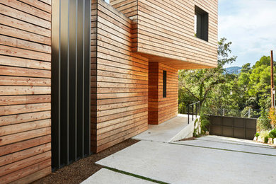 Diseño de fachada marrón actual de dos plantas con revestimiento de madera y tejado plano