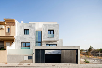 Inspiration pour une grande façade de maison grise design en pierre à deux étages et plus avec un toit plat.