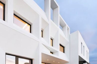 Foto de fachada blanca minimalista grande de tres plantas con revestimientos combinados y tejado plano