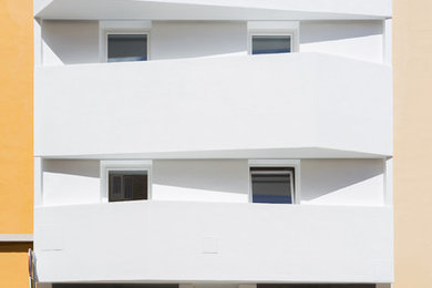 Ejemplo de fachada de casa pareada blanca minimalista de tres plantas