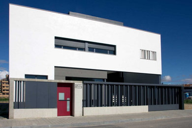 Foto de fachada blanca moderna de tamaño medio de tres plantas con revestimiento de estuco y tejado plano