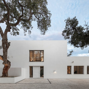 Imagen de fachada de casa blanca, moderna, grande, de dos plantas, con revestimiento de estuco y tejado plano