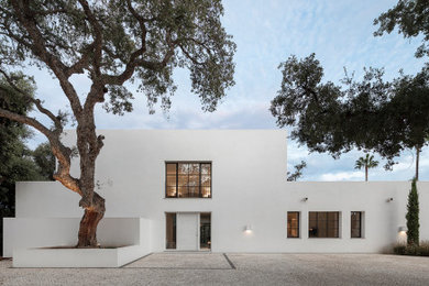 Imagen de fachada de casa blanca moderna grande de dos plantas con revestimiento de estuco y tejado plano