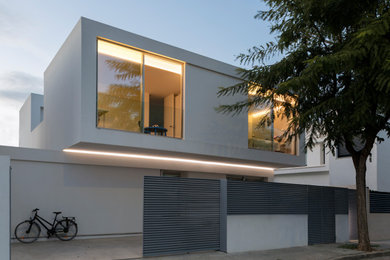Modelo de fachada de casa blanca moderna de tamaño medio de dos plantas con revestimiento de aglomerado de cemento, tejado plano y tejado de varios materiales