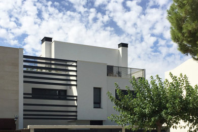 Ejemplo de fachada de casa pareada blanca contemporánea de tamaño medio con revestimiento de aglomerado de cemento, tejado plano y tejado de varios materiales